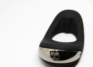 A close up image of the Hot Octopuss ATOM PLUS Cock Ring against a white backdrop. Focus on the logo.
